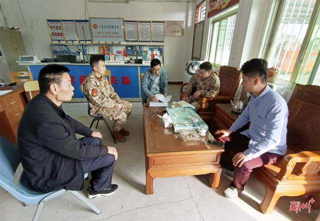 縣人武部主要領導易定富在聯饒鎮下寨村了解應征青年報名情況。